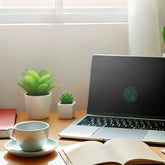 A calming and organized blog photo representing work-life balance for remote workers. The image shows a home office setup with a laptop, a cup of coff